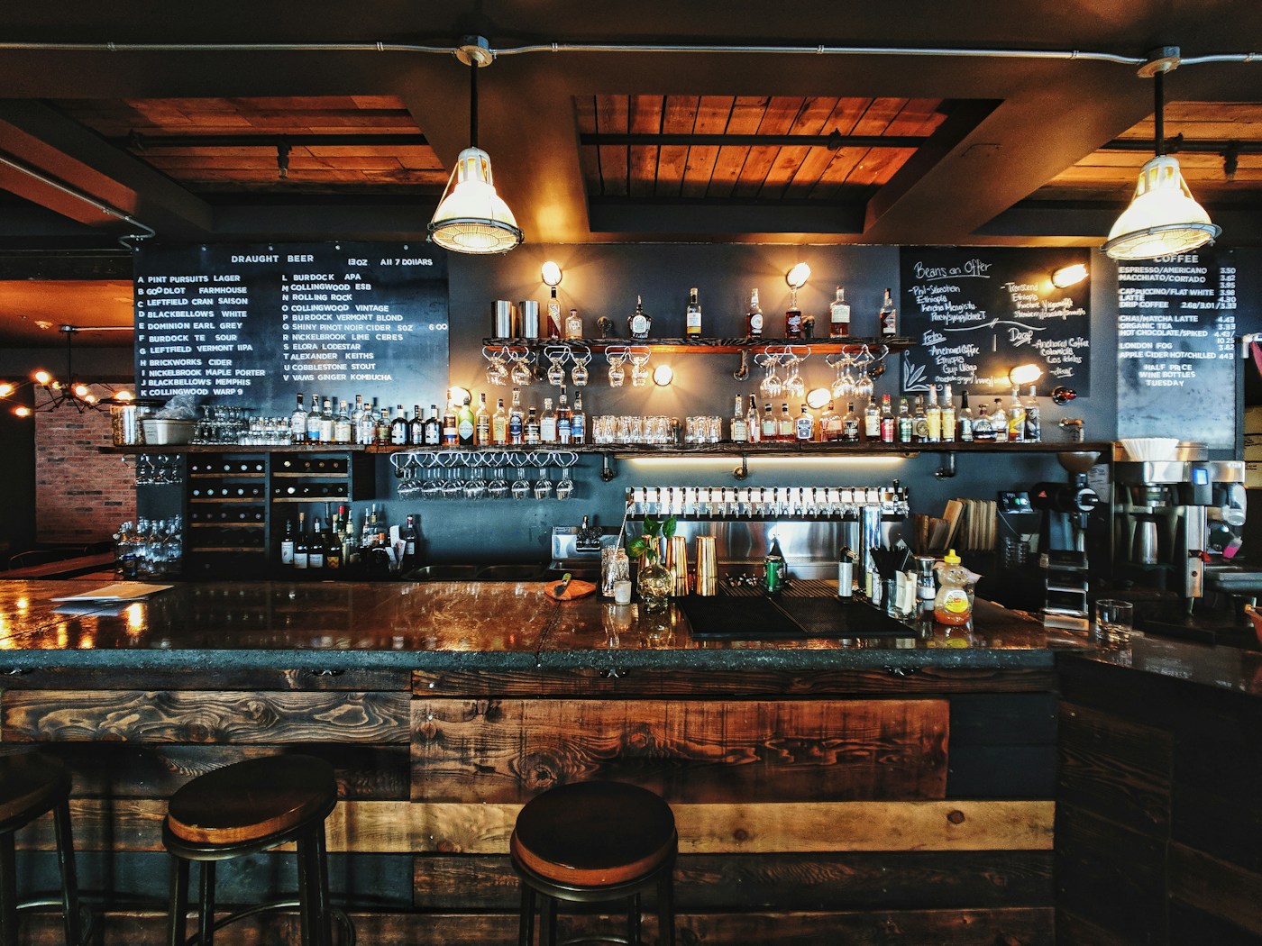 A welcoming wood-panelled bar with warm lights and rows of taps